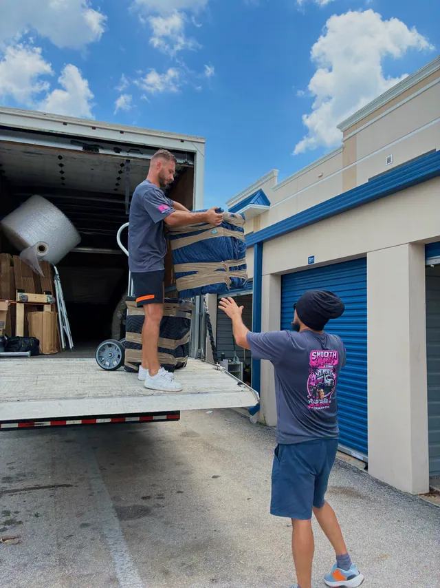 Crew carrying a roll of protective wrap to the truck